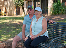 A couple sitting on a bench.